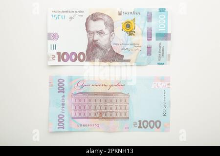 1000 neue Banknote der Ukraine auf weißem Hintergrund. Sparen und Geld sparen. Ukrainisches Geld. Draufsicht Stockfoto