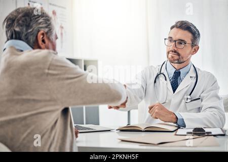 Ich werde den Weg zur Genesung mit dir gehen. Ein freundlicher Arzt, der mit seinem erwachsenen Patienten die Hand über dem Tisch schüttelt. Stockfoto
