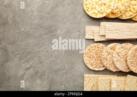 Verschiedene Arten von gesunden Vollkorn-Knäckebrot auf grauem Hintergrund. Draufsicht Stockfoto