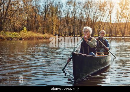 Er ist ihr Mann und Kanu-Kumpel. Ein Seniorenpaar, das eine Kanufahrt auf dem See macht. Stockfoto
