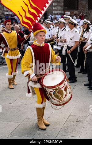 Siena, Italien - August 14 2022: Valdimontone Contrada Drummer und Fahnenträger bei der Prozession der Kerzen und Zensoren vor dem Palio. Stockfoto