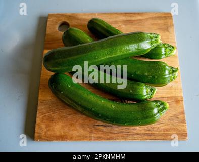 Frisch gepflückte Zucchini aus dem Garten auf einem Holzbrett Stockfoto