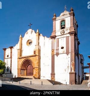 Die Kathedrale Sé Catedral de Silves, ein nationales Denkmal mit einem Hauptportal im gotischen Stil und einem seitlichen Portal im Barockstil, steht hoch unter dem sonnigen Himmel. Stockfoto