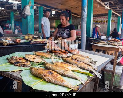 Iquitos, Peru - 2018. März: Gebackener Fisch und andere lokale Köstlichkeiten auf dem Belavista-Markt am Amazonasufer. Amazon. Südamerika Stockfoto