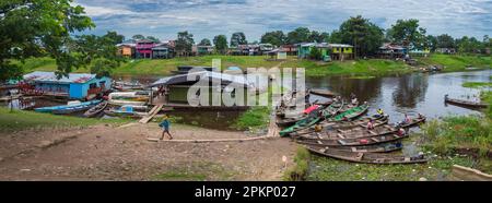 Leticia, Kolumbien - Dez. 2021: Hölzerne Boote und Häuser auf dem Pfahl im Hafen in einer tropischen Zone in einem Dorf am Ufer des Amazonas während t Stockfoto