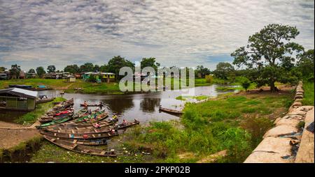 Leticia, Kolumbien - Dez. 2021: Hölzerne Boote und Häuser auf dem Pfahl im Hafen in einer tropischen Zone in einem Dorf am Ufer des Amazonas während t Stockfoto