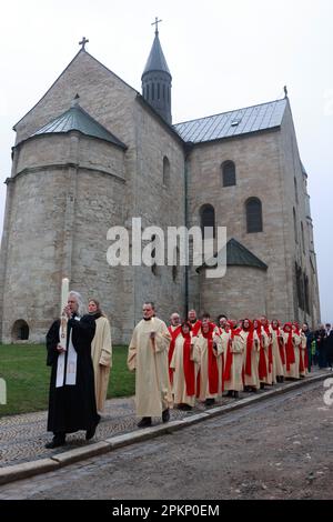 Gernrode, Deutschland. 09. April 2023. Mit einer Prozession ziehen die 22 Schauspieler mit Pfarrer Andreas Müller (l) aus der Kollegialkirche St. Cyriakus durch das Dorf. Traditionell wurde das Osterspiel am Ostersonntag in der Kollegialkirche aufgeführt. Kredit: Matthias Bein/dpa/Alamy Live News Stockfoto