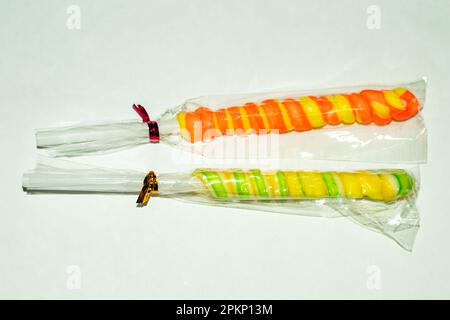 Einen mehrfarbigen Schokoladenlutscher, der entweder mit Kohlensäure oder Gummibonbons gefüllt ist. Diese mehrfarbigen Süßigkeiten mit Milchschokolade und Zuckerbeschichtung bieten Ihnen Ihr Interesse Stockfoto