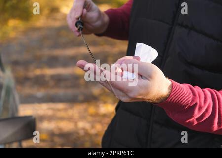 Ein Mann überprüft den Ölstand im Automotor. Selbstbedienung des Autos. Regelmäßige Überprüfung des Ölstands im Motor. Stockfoto
