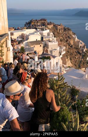 Touristen beobachten den Sonnenuntergang von der Kasteli (Burg) von Agios Nikolaos, Oia, Santorin, Griechenland, Europa Stockfoto