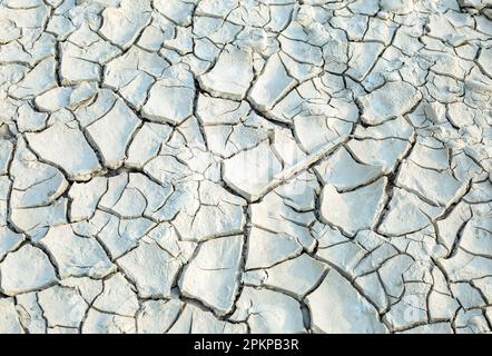 Textur, Hintergrund von trockenem, gerissenem Erdboden. Tiefe Risse im Boden als Symbol für heißes Klima und Dürre. Weltweite Wasserknappheit auf dem Planeten. Konzept Stockfoto