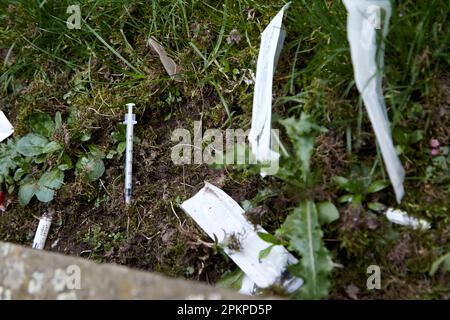 Gebrauchte Nadeln Spritzen und Drogenutensilien, die im öffentlichen Parkbereich des Writers Square Cathedral Quarter Belfast City Centre, Nordirland, entsorgt wurden, Stockfoto