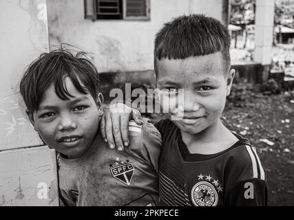 Zwei junge Jungs aus der ethnischen Minderheit Jerais mit gefälschten Fußballtrikots stehen zusammen im Bezirk Chu Prong, Provinz Gia Lai, Vietnam. Stockfoto