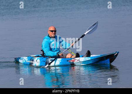 Sandbanks, Poole, Dorset, Großbritannien. 9. April 2023 Wetter im Vereinigten Königreich: Warm und sonnig im Sandbanks in Poole, wo leidenschaftliche Wassersportfreunde und -Enthusiasten ihre Aktivitäten im Sonnenschein auf dem Wasser genießen. Heute, der Ostersonntag, wird laut Prognose der heißeste Tag des Jahres bis jetzt sein, mit der Vorhersage von morgen Regen. Kajakfahrer. Kredit: Carolyn Jenkins/Alamy Live News Stockfoto