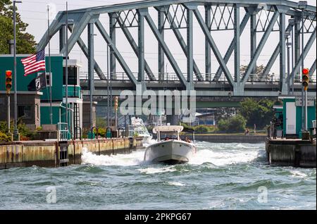 Boote, die sich an einem frühen Sommertag durch das raue Wasser der offenen Schleusen im Shinnecock Canal bewegen. Stockfoto