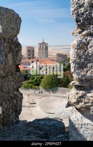 Blick zwischen den Merlons der Festung (alcazaba) von Trujillo auf der Kirche Santa Maria la Mayor. Trujillo, Extremadura, Spanien. Stockfoto