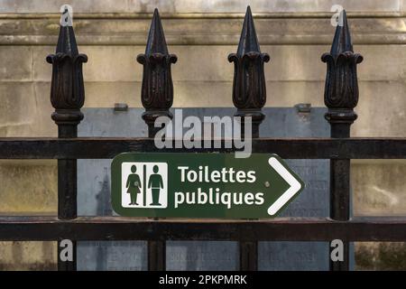 Grünes Schild für öffentliche Toiletten auf Französisch auf einem Zaun in Paris, Frankreich. Stockfoto