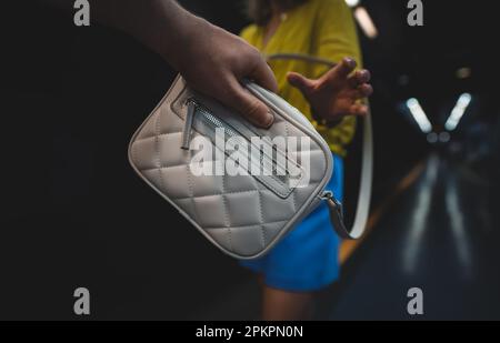 Der Dieb stiehlt einer Frau in der U-Bahn eine Tasche. Stockfoto