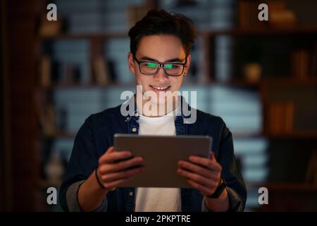 Lächelnder junger Mann, der im Büro einen digitalen Tablet-pc benutzt Stockfoto