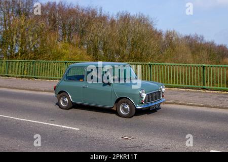 1979 70s Siebzigerjahre Green Austin Morris Mini 850 Super, Benzin 998 ccm; Überquerung der Autobahnbrücke im Großraum Manchester, Großbritannien Stockfoto