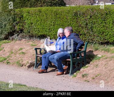 Ein pensioniertes Paar liest im Park Zeitung Stockfoto