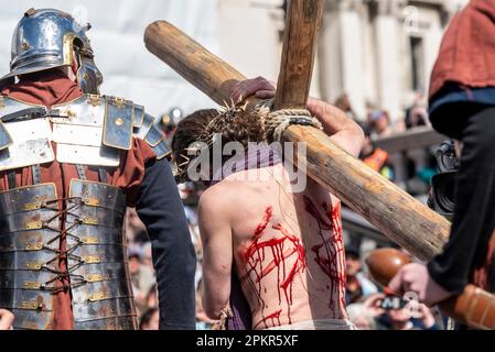 The Passion of Christ Open Air-Spiel von Wintershall am Trafalgar Square, London, am OsterKarfreitag. Christus trägt das Kreuz mit Blut vom Peitschen Stockfoto