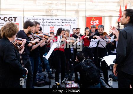 Die SDAMP-CGT-Mitglieder treten am 9. April 2023 auf dem Place du Palais Royal in Paris, Frankreich, während eines Konzerts eines Symphonieorchesters auf, um gegen eine Rentenreform zu protestieren, wie sich der Staatsrat in Spiegeln widerspiegelt. Musiker interpretierten insbesondere Werke von Beethoven und Bizet… die Proteste dauern in Frankreich an, nachdem der Präsident am 16. März unter Anwendung von Artikel 49,3 der Verfassung das parlament umgangen hatte, um eine Rentenreform zu verabschieden, die eine Anhebung des Rentenalters von 62 auf 64 Jahre einschließt. Foto: Pierrick Villette/ABACAPRESS.COM Stockfoto