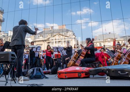 Die SDAMP-CGT-Mitglieder treten am 9. April 2023 auf dem Place du Palais Royal in Paris, Frankreich, während eines Konzerts eines Symphonieorchesters auf, um gegen eine Rentenreform zu protestieren, wie sich der Staatsrat in Spiegeln widerspiegelt. Musiker interpretierten insbesondere Werke von Beethoven und Bizet… die Proteste dauern in Frankreich an, nachdem der Präsident am 16. März unter Anwendung von Artikel 49,3 der Verfassung das parlament umgangen hatte, um eine Rentenreform zu verabschieden, die eine Anhebung des Rentenalters von 62 auf 64 Jahre einschließt. Foto: Pierrick Villette/ABACAPRESS.COM Stockfoto