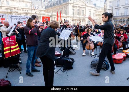 Die SDAMP-CGT-Mitglieder treten am 9. April 2023 auf dem Place du Palais Royal in Paris, Frankreich, während eines Konzerts eines Symphonieorchesters auf, um gegen eine Rentenreform zu protestieren, wie sich der Staatsrat in Spiegeln widerspiegelt. Musiker interpretierten insbesondere Werke von Beethoven und Bizet… die Proteste dauern in Frankreich an, nachdem der Präsident am 16. März unter Anwendung von Artikel 49,3 der Verfassung das parlament umgangen hatte, um eine Rentenreform zu verabschieden, die eine Anhebung des Rentenalters von 62 auf 64 Jahre einschließt. Foto: Pierrick Villette/ABACAPRESS.COM Stockfoto