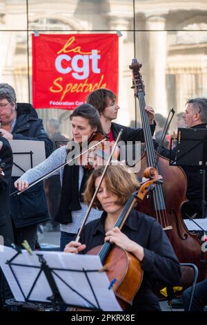 Die SDAMP-CGT-Mitglieder treten am 9. April 2023 auf dem Place du Palais Royal in Paris, Frankreich, während eines Konzerts eines Symphonieorchesters auf, um gegen eine Rentenreform zu protestieren, wie sich der Staatsrat in Spiegeln widerspiegelt. Musiker interpretierten insbesondere Werke von Beethoven und Bizet… die Proteste dauern in Frankreich an, nachdem der Präsident am 16. März unter Anwendung von Artikel 49,3 der Verfassung das parlament umgangen hatte, um eine Rentenreform zu verabschieden, die eine Anhebung des Rentenalters von 62 auf 64 Jahre einschließt. Foto: Pierrick Villette/ABACAPRESS.COM Stockfoto