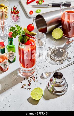 LONDON, Großbritannien - 15. MÄRZ 2023: Bloody mary Cocktail mit Tabasco, Sieb, Schüttler, Limette und Pfeffer auf Light Board. Stockfoto