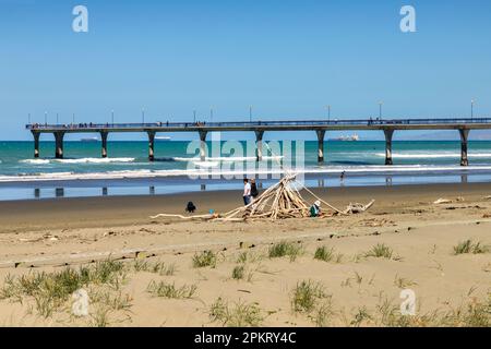 31. Dezember 2022: Christchurch, Neuseeland - New Brighton Beach, mit Stäbchenschutz oder Strandschutz, und New Brighton Pier. Stockfoto