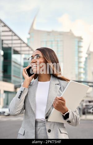 Vertikales Porträt einer afroamerikanischen Geschäftsfrau, die draußen telefoniert. Stockfoto