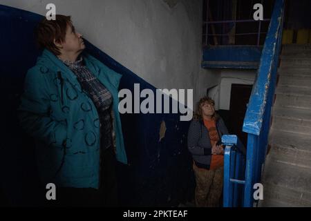 6. April 2023, Borodyanka, Ukraine: Olla (R), Bewohner von Borodyanka und ihr Nachbar sagte, dass ihr Gebäude einst von einem russischen Scharfschützen besetzt war. Im vergangenen November wurden Fenster installiert, das Dach und einige Wände sind jedoch immer noch kaputt. Trotz der einjährigen Befreiung von Borodyanka, einer Stadt nordwestlich der ukrainischen Hauptstadt Kiew, sind die Bewohner von Borodyanka nicht zur Normalität zurückgekehrt. Der Wiederaufbauprozess verlief stetig, aber langsam, zerstörte Gebäude bleiben im Stadtzentrum. Viele Bewohner haben in beschädigten Gebäuden gelebt, die jetzt teilweise repariert sind, während andere, die ihr Zuhause verloren haben, St. Stockfoto