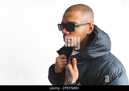 Mittelgroße Nahaufnahme eines jungen, stilvollen Mannes mit Sonnenbrille daneben, weißer Hintergrund. Hochwertiges Foto Stockfoto
