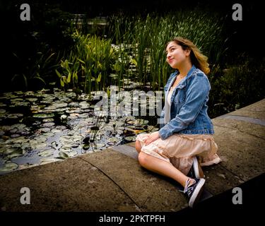 Asiatische Teenagerin neben einem Lily Pond | De Young Museum Stockfoto