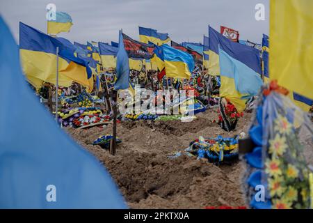 Frische Gräber mit ukrainischen Flaggen von Soldaten, die im Krieg auf einem der Charkiv Friedhöfe getötet wurden. Jeden Tag werden aufgrund der russischen Invasion der Ukraine mehrere hundert Ukrainer getötet. Stockfoto