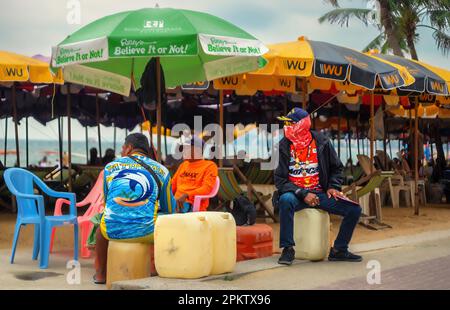 Pattaya, Thailand - Oktober 16,2022: Strand drei thailändische Männer in bunten Kleidern warteten auf die nächste Touristengruppe. Stockfoto