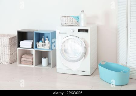 Beim Waschen im Zimmer tritt Schaum aus der defekten Waschmaschine aus Stockfoto