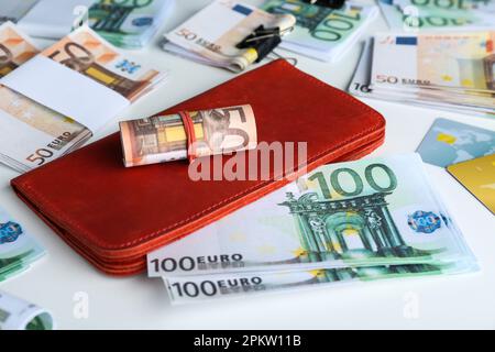 Brieftasche, verschiedene Euro-Banknoten und Kreditkarten auf weißem Tisch, Nahaufnahme. Geldwechsel Stockfoto