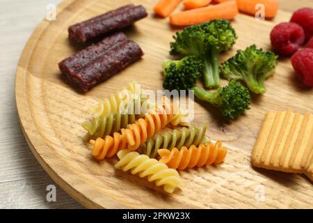 Holzbrett mit verschiedenen Fingerfood für Babys auf dem Tisch, Nahaufnahme Stockfoto