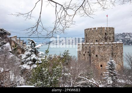 Rumeli Festung, eine alte Burg mit schneebedeckten Blicken im Winter, Istanbul, Türkiye. Schloss Rumeli mit Fatih Sultan Mehmet-Brücke und Bosporus in t Stockfoto