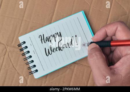 Notizbuch geschrieben mit Text HAPPY WEEKEND! Über Korkbretthintergrund. Stockfoto