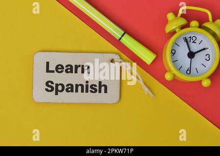 Uhr, Stift und Holzanhänger mit SPANISCH LERNEN. Stockfoto