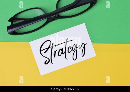Draufsicht auf Brille und Memo mit STRATEGIE. Stockfoto