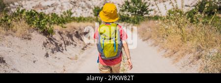 BANNER, LANGFORMAT Boy Tourist, der das Tal mit Felsformationen und Feenhöhlen in der Nähe von Goreme in Kappadokien, Türkei, erkundet Stockfoto