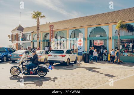 Pismo Beach, Kalifornien, USA - 6. April 2023. Pismo Beach Pier plaza, Geschäfte und Restaurants, und ruhende Leute Stockfoto