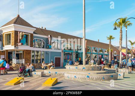 Pismo Beach, Kalifornien, USA - 6. April 2023. Pismo Beach Pier plaza, Geschäfte und Restaurants, und ruhende Leute Stockfoto