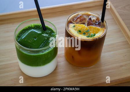 Eismatcha greentea und schwarzer Orangenkaffee auf Holztisch, Stockfoto Stockfoto