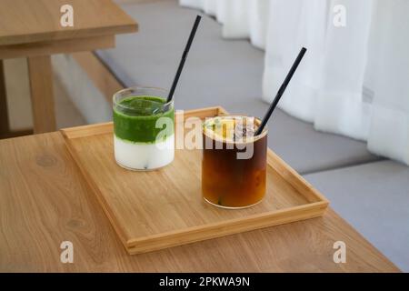 Eismatcha greentea und schwarzer Orangenkaffee auf Holztisch, Stockfoto Stockfoto